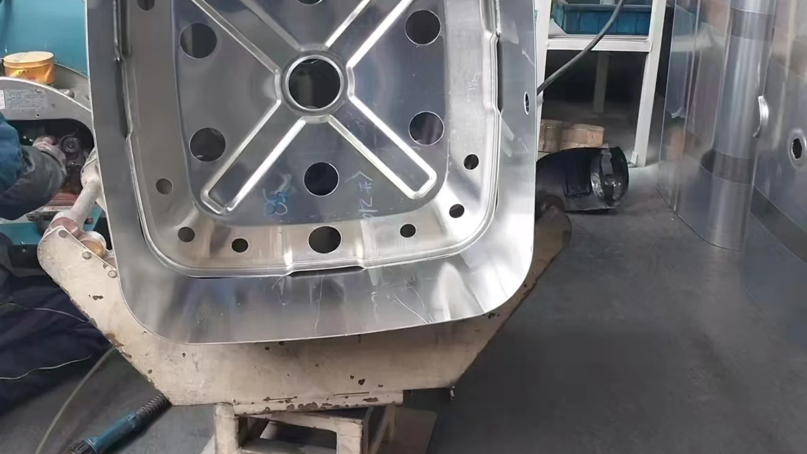 Formed rectangular metal tank shell held in a production fixture