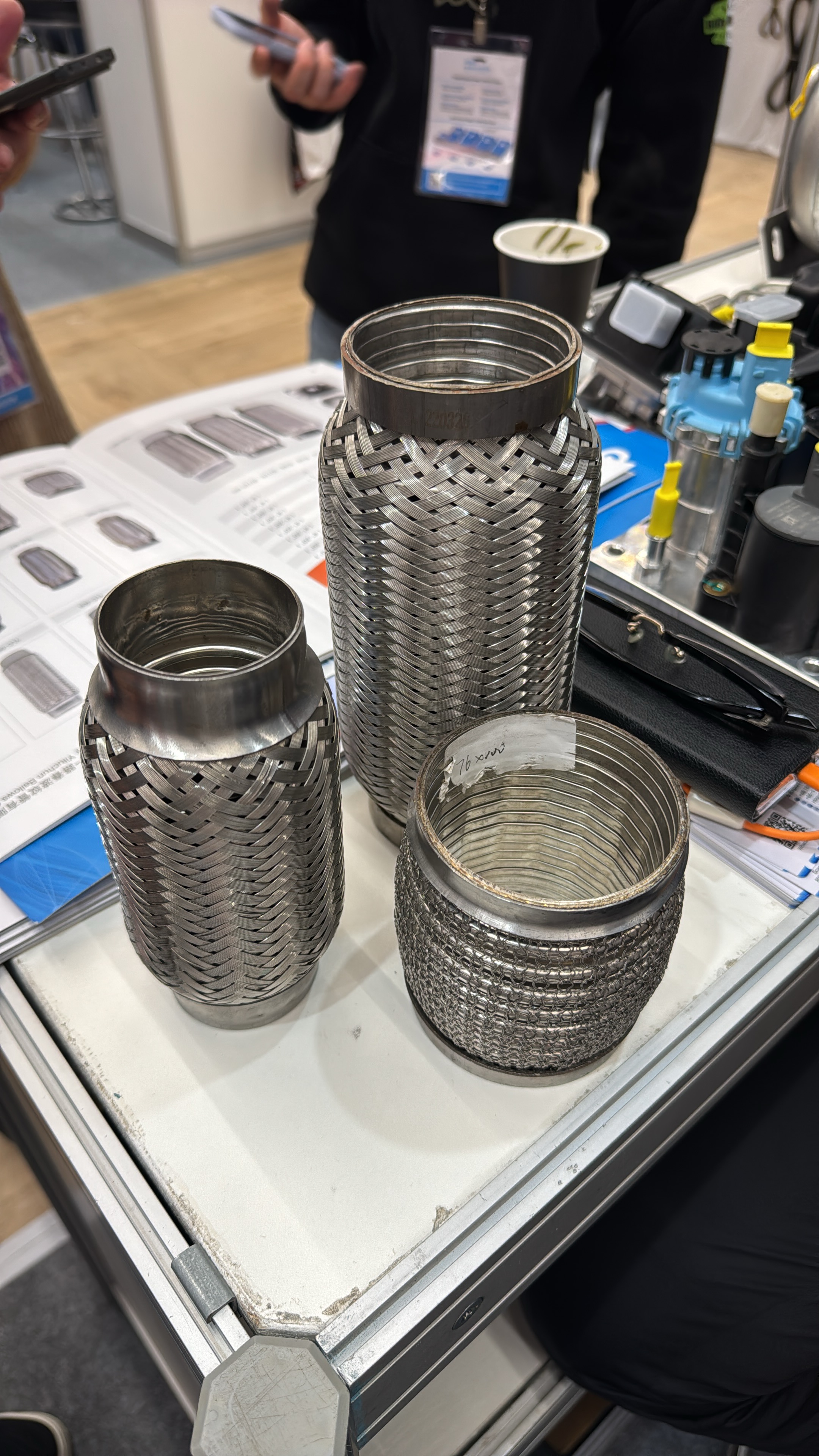 Heavy-duty stainless steel flexible exhaust bellows and multi-layer braided pipes displayed on the exhibition counter