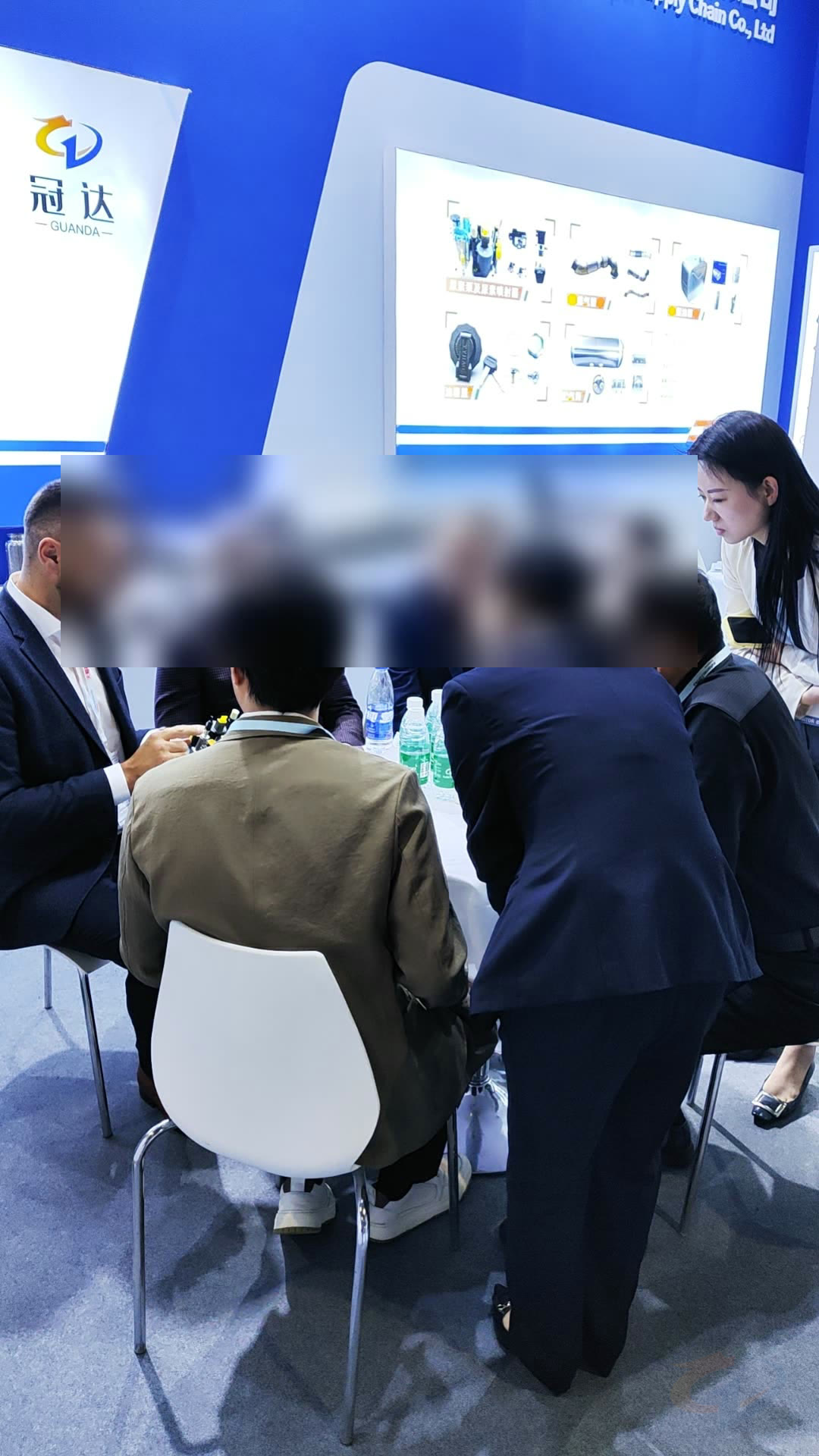 Guanda team discussing truck components with customers at an exhibition booth
